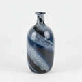 An elegant glass vase with a blue swirl design is centered on a clean white studio background with soft, even lighting and a subtle contact shadow.